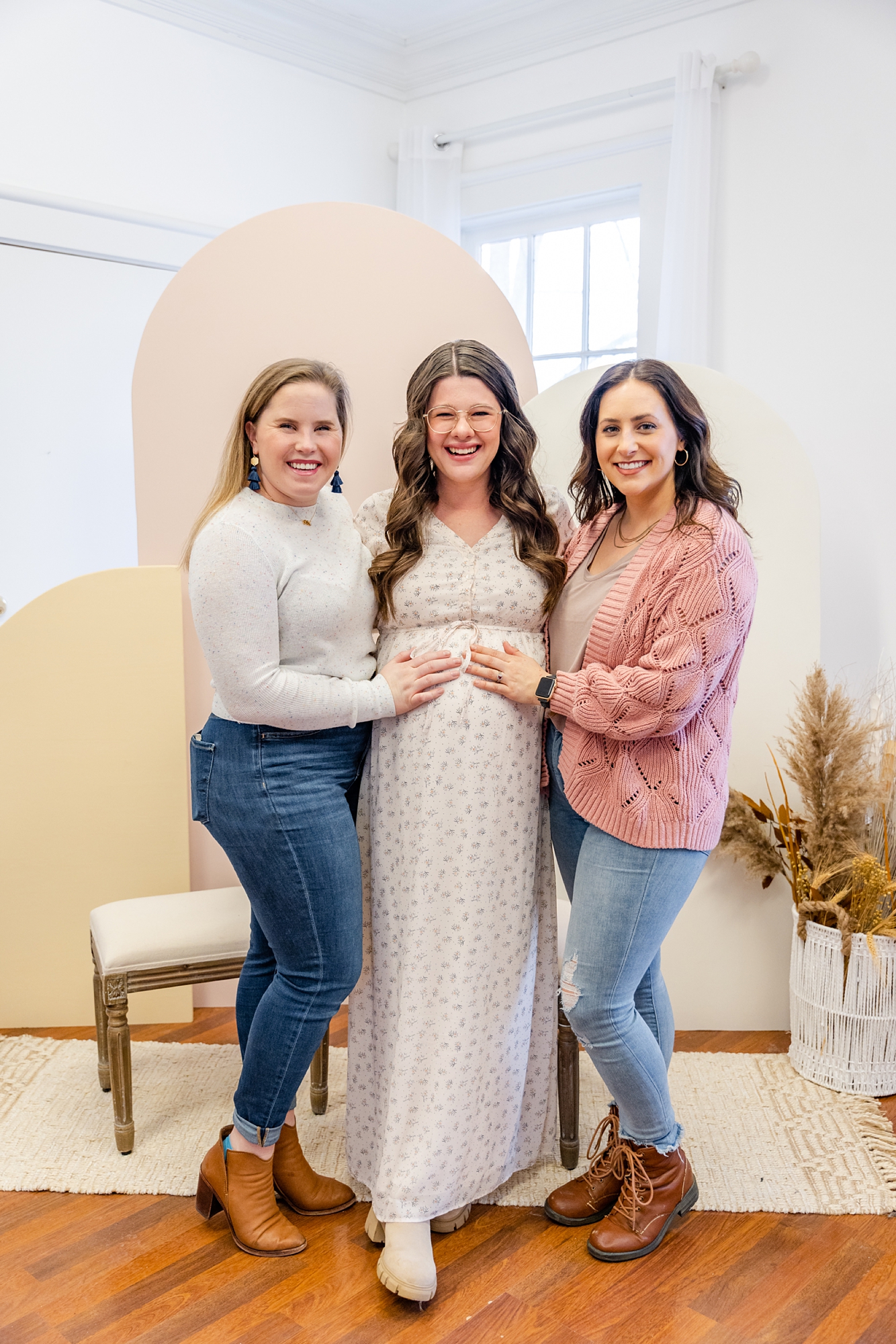 guests hold mom's belly during baby shower
