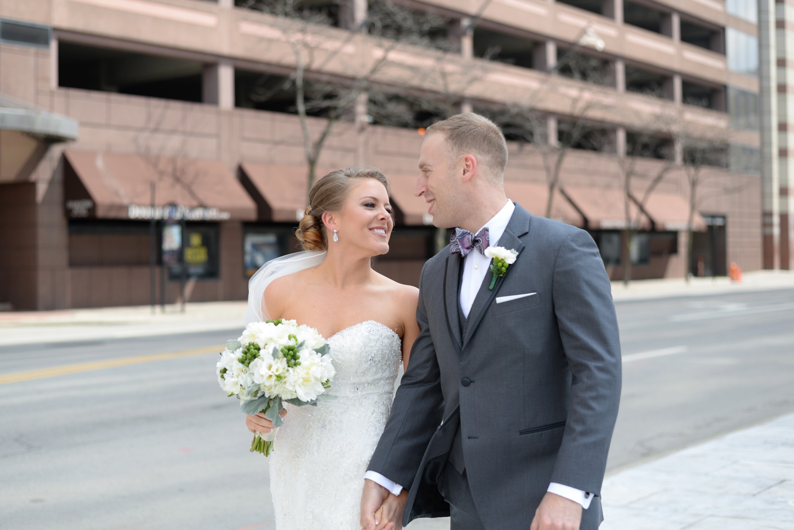 the-bride-and-groom-are-walking-down-a-street-in-columbus