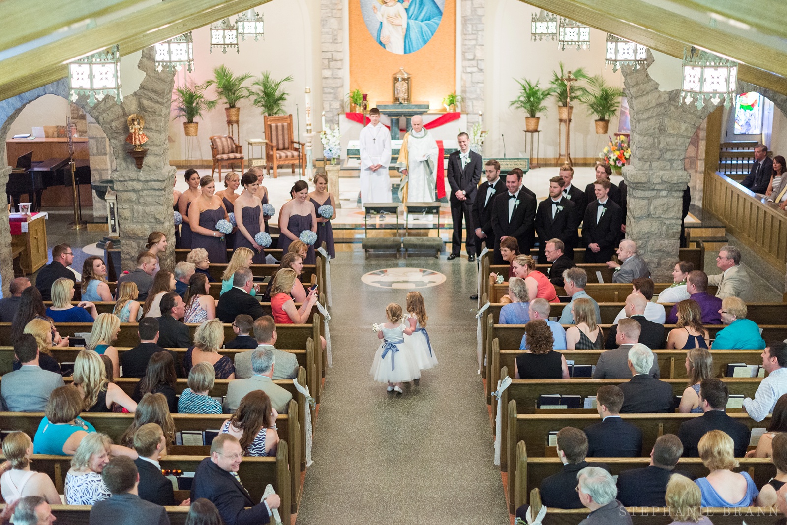 girls-walking-down-the-aisle-before-a-wedding-at-a-catholic-church