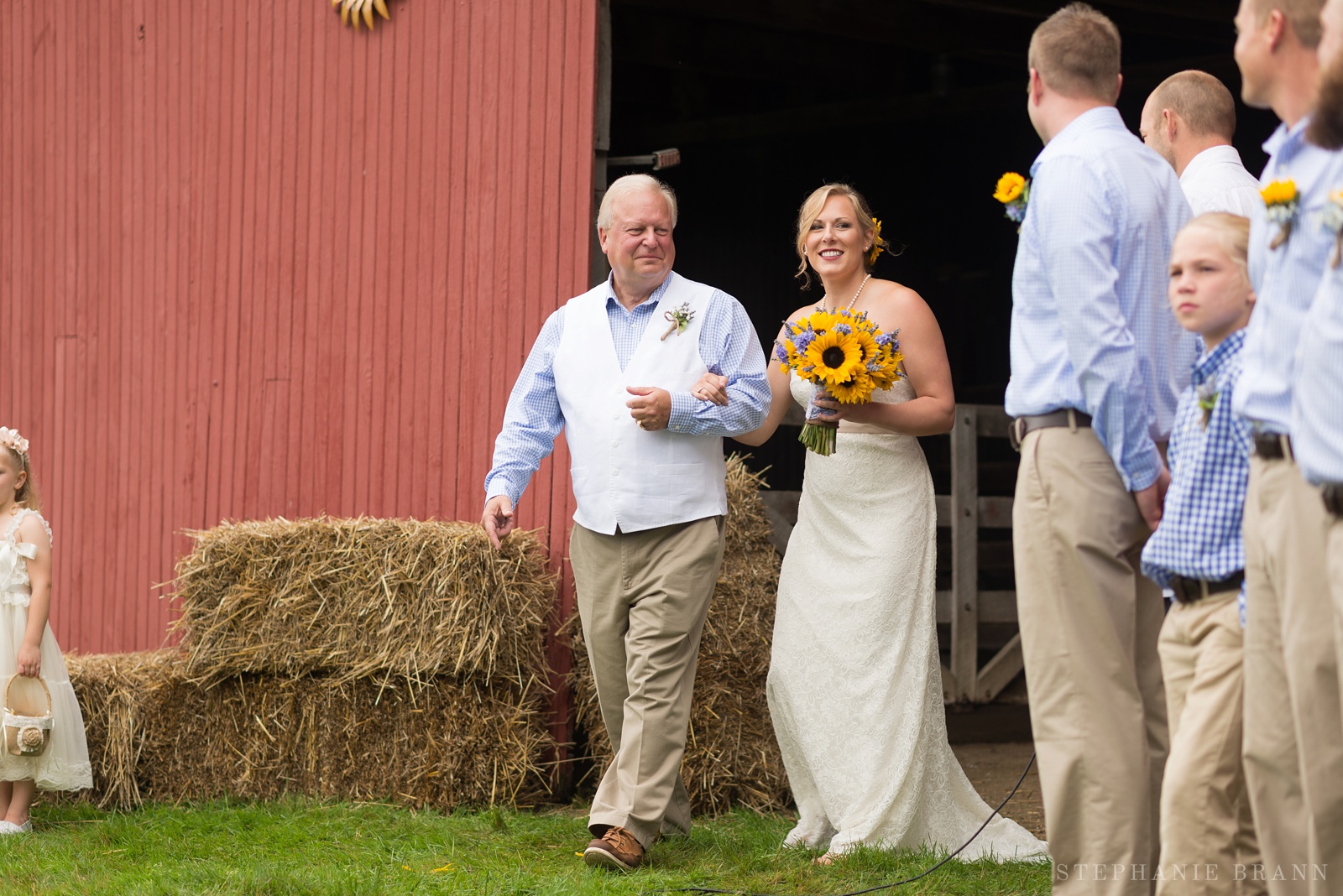 bride-walking-through-a-barn-to-the-ceremony