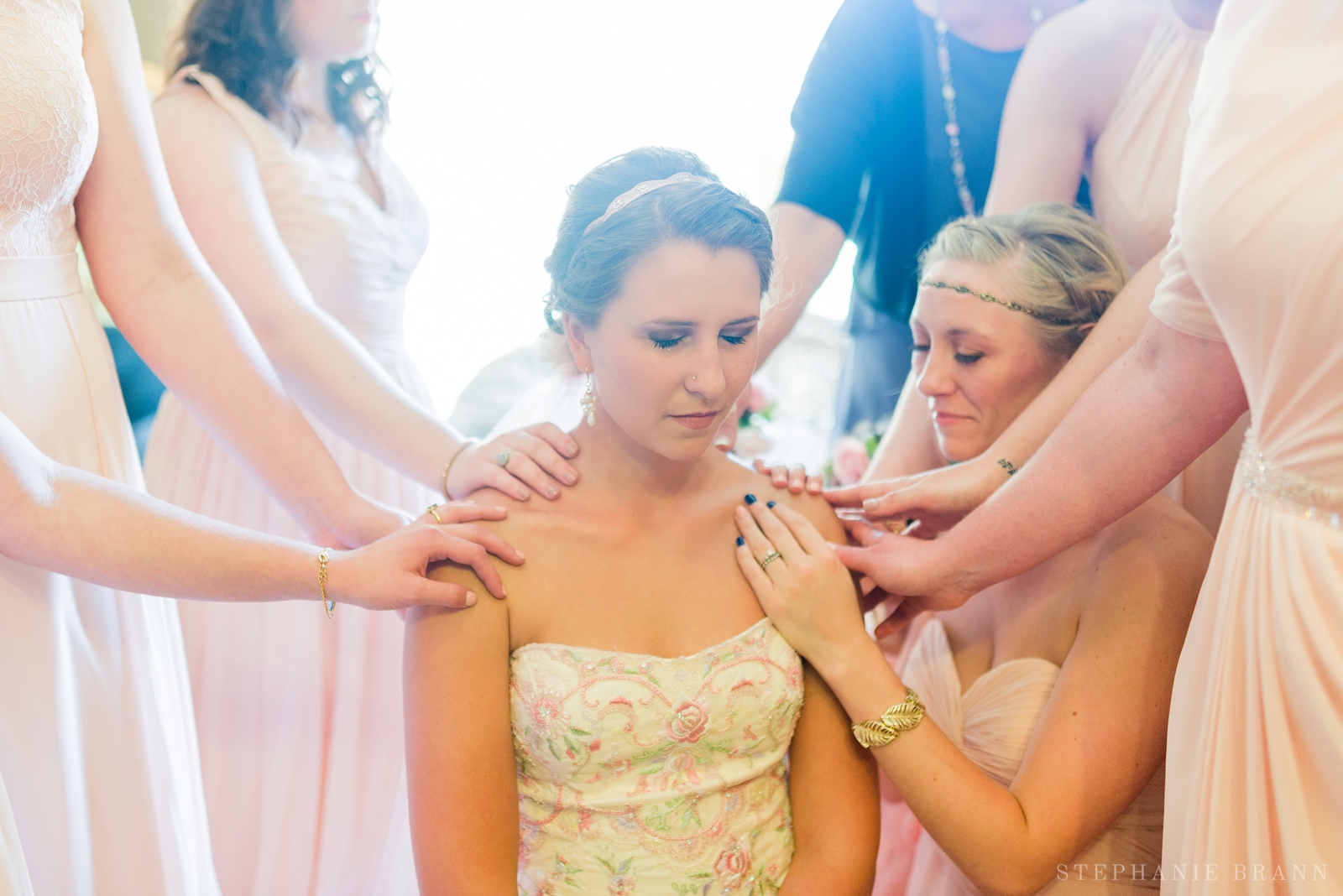 group-of-friends-praying-and-laying-their-hands-on-the-bride