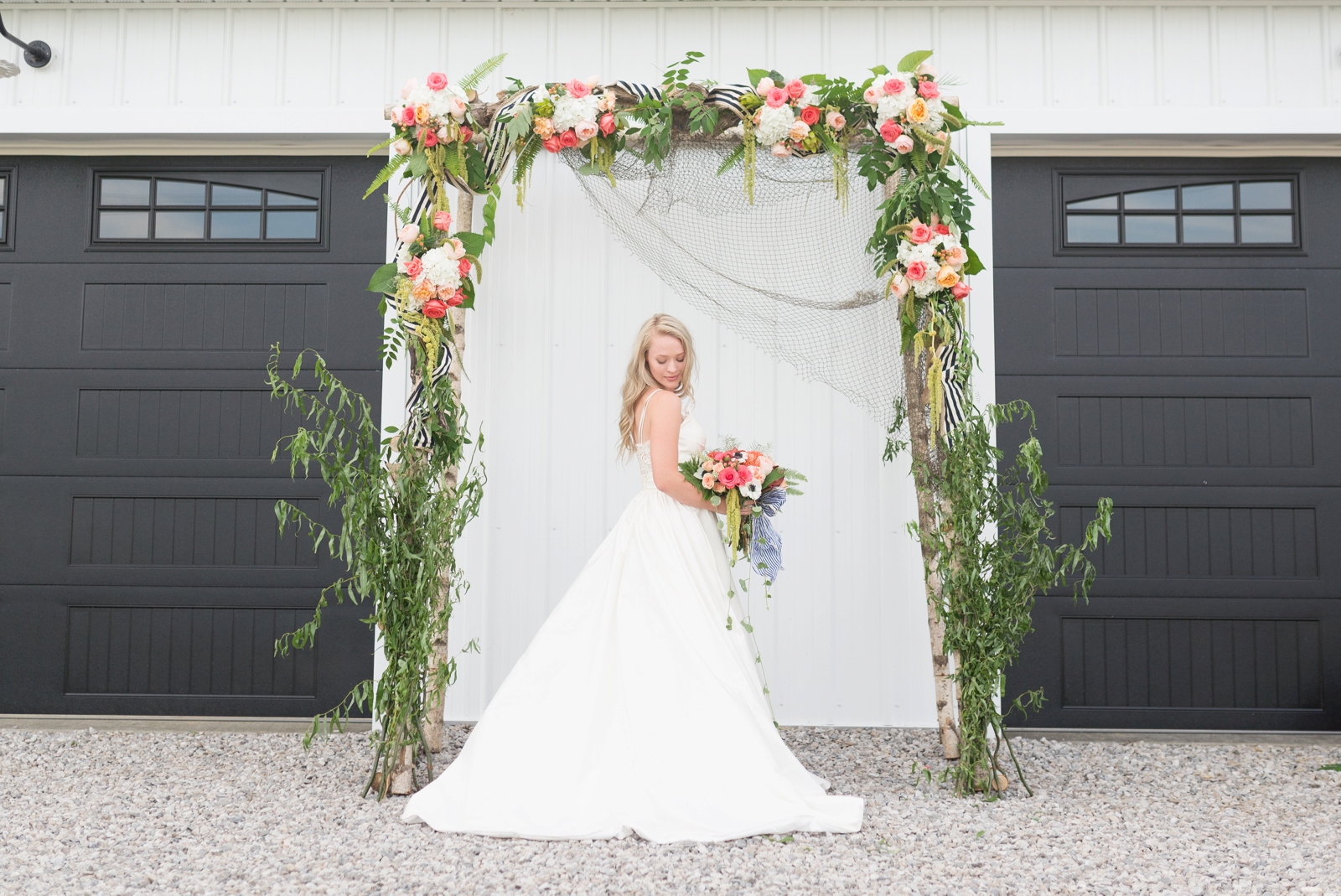 girl-holding-flowers-under-a-flower-arch