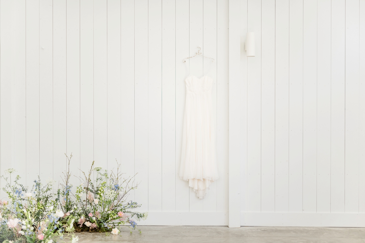 bridal-wedding-dress-hanging-on-a-white-wall