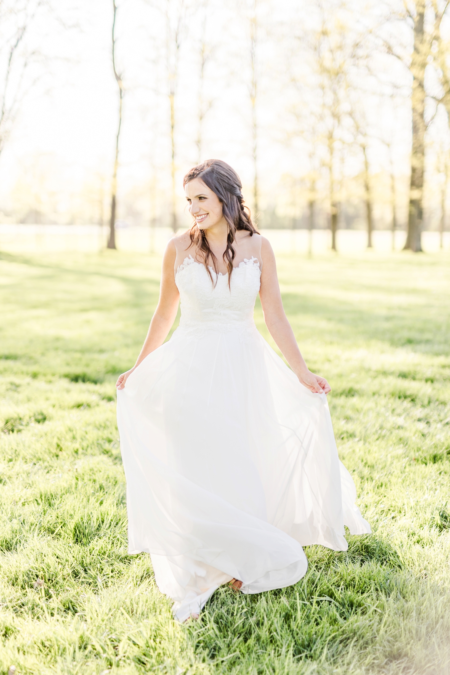 bride-walking-with-a-flowy-wedding-dress-in-the-wind-thorugh-a-sunset-field