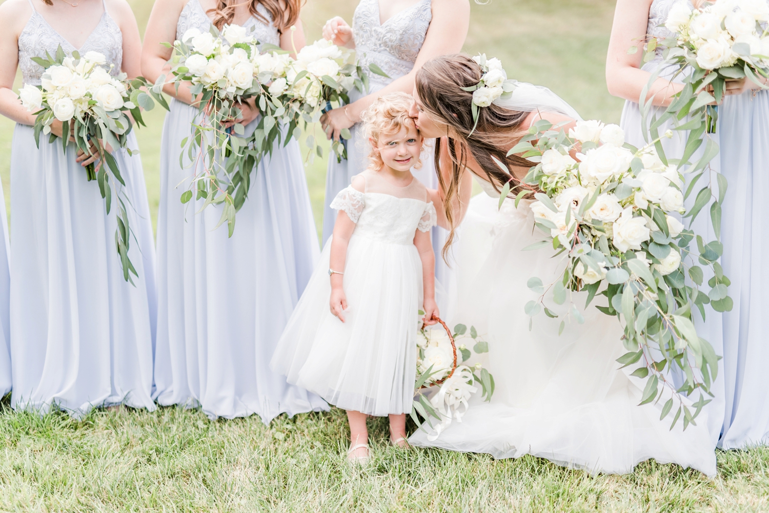 Bride-reaching-down-to-kiss-the-flower-girl