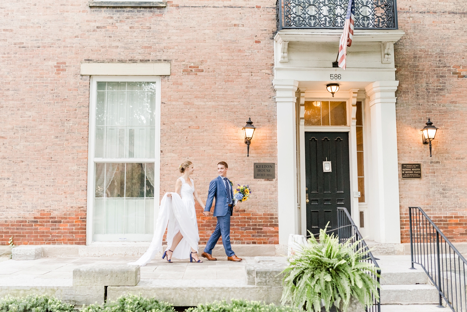 bride-and-groom-walking-in-front-of-the-kelton-house