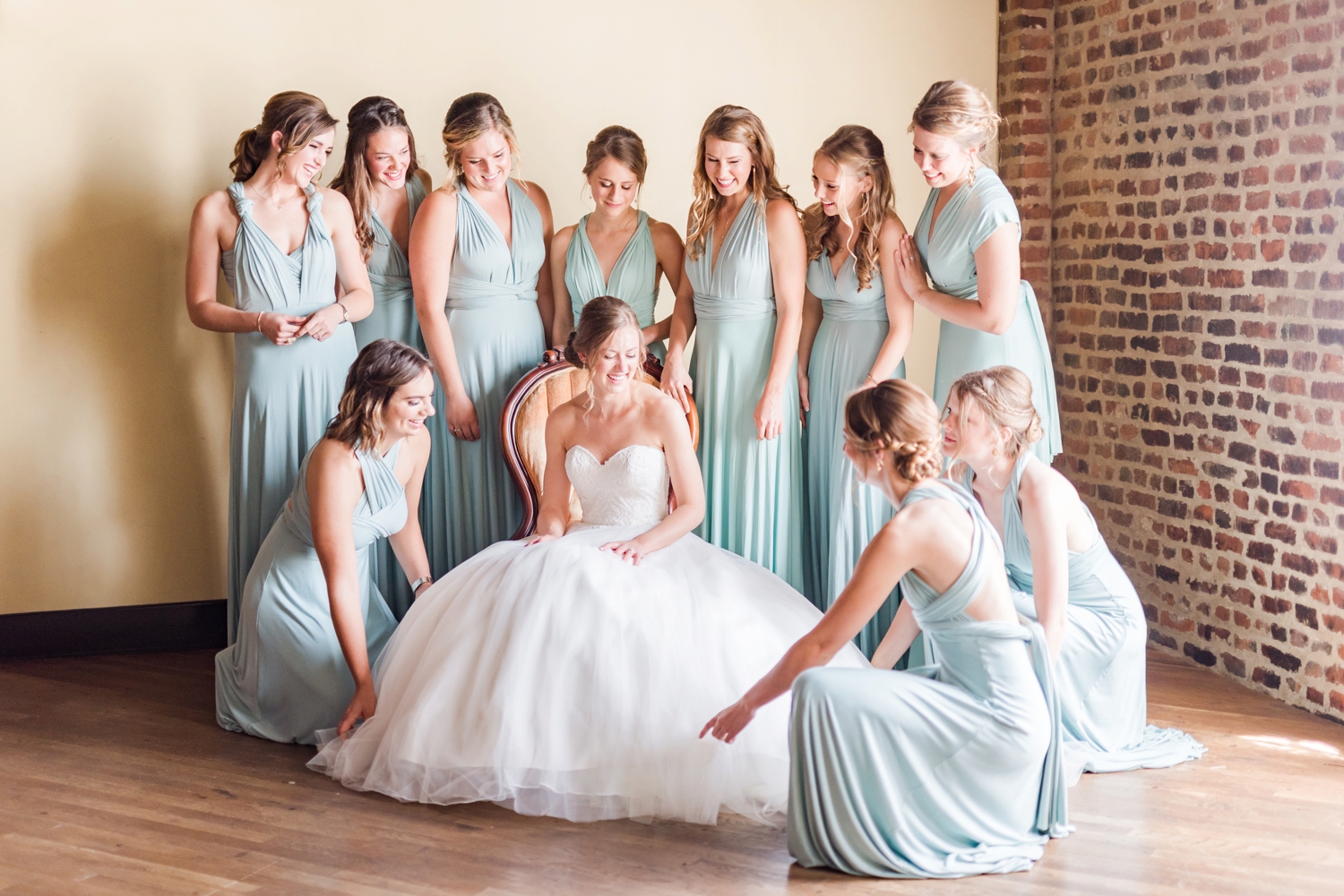 bridesmaids-helping-the-bride-fluff-her-dress-with-light-blue-dresses