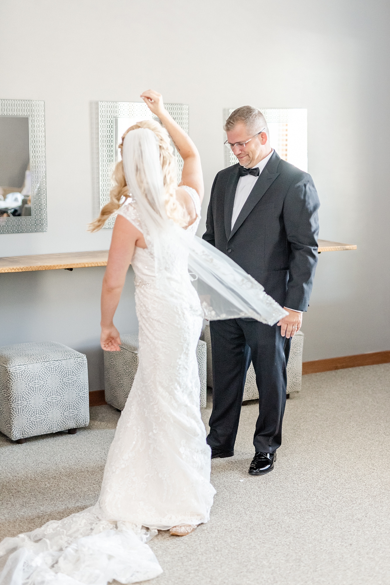 bride shows off veil to father during father-daughter first look