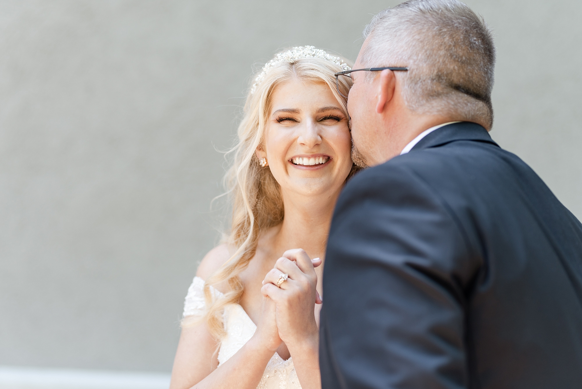 father kisses bride before first look with groom