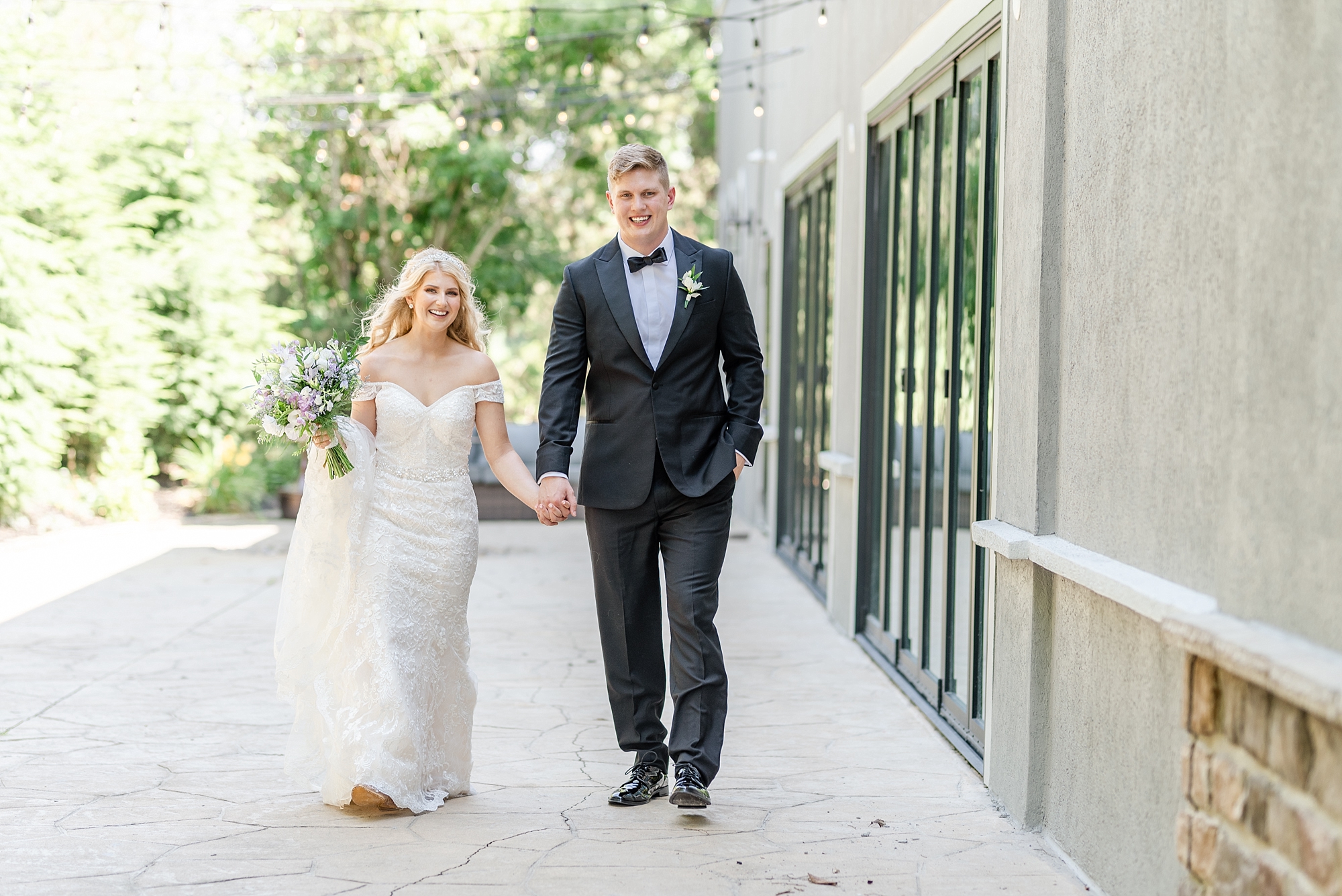 bride and groom hold hands walking along Brookshire in Ohio