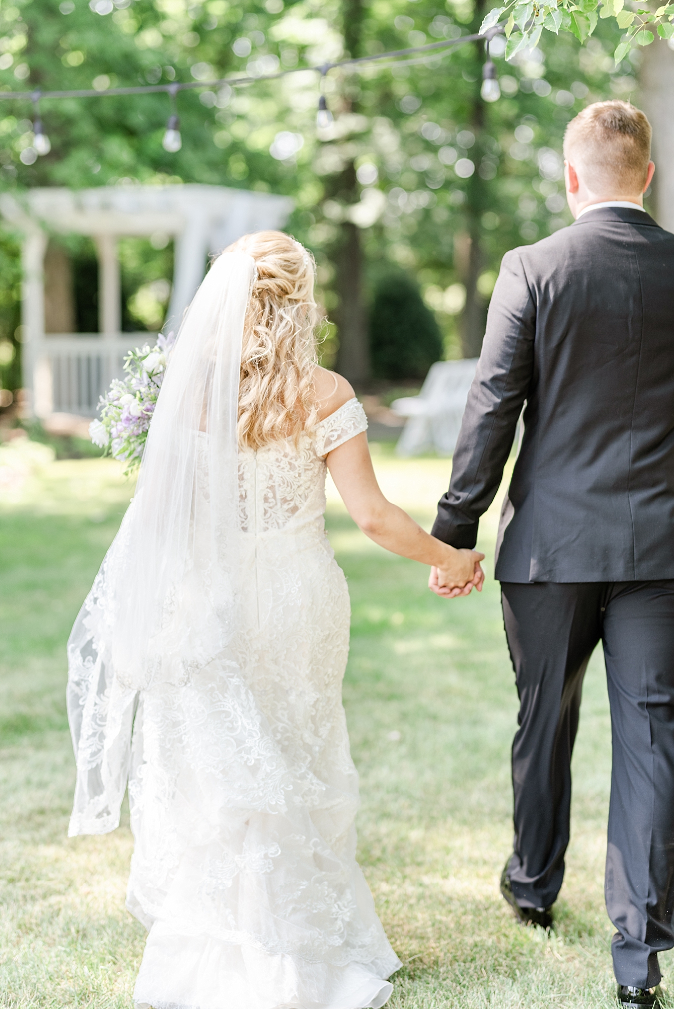 bride and groom hold hands walking toward gazebo at Brookshire