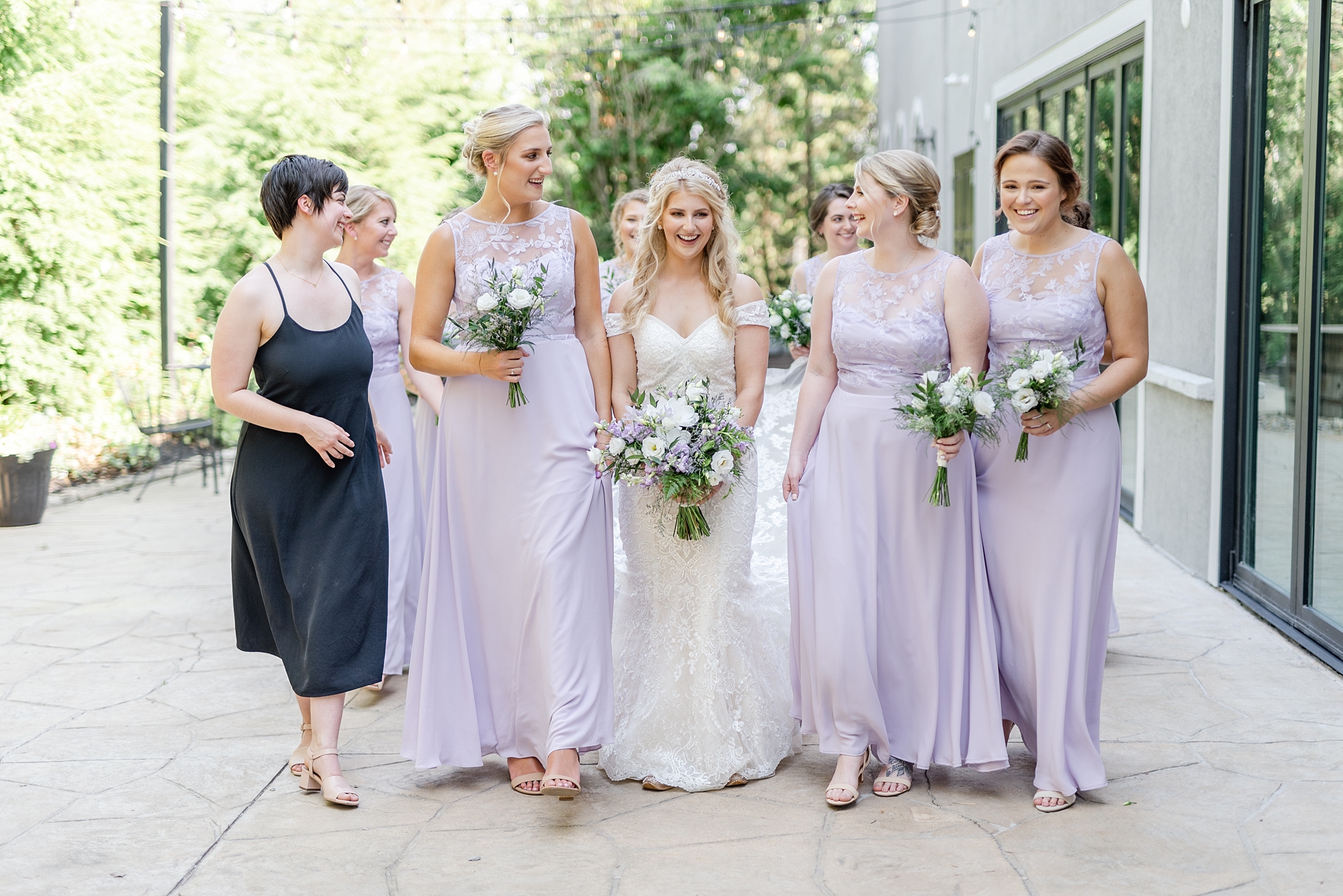 bride walks with bridesmaids in lavender bridesmaid gowns