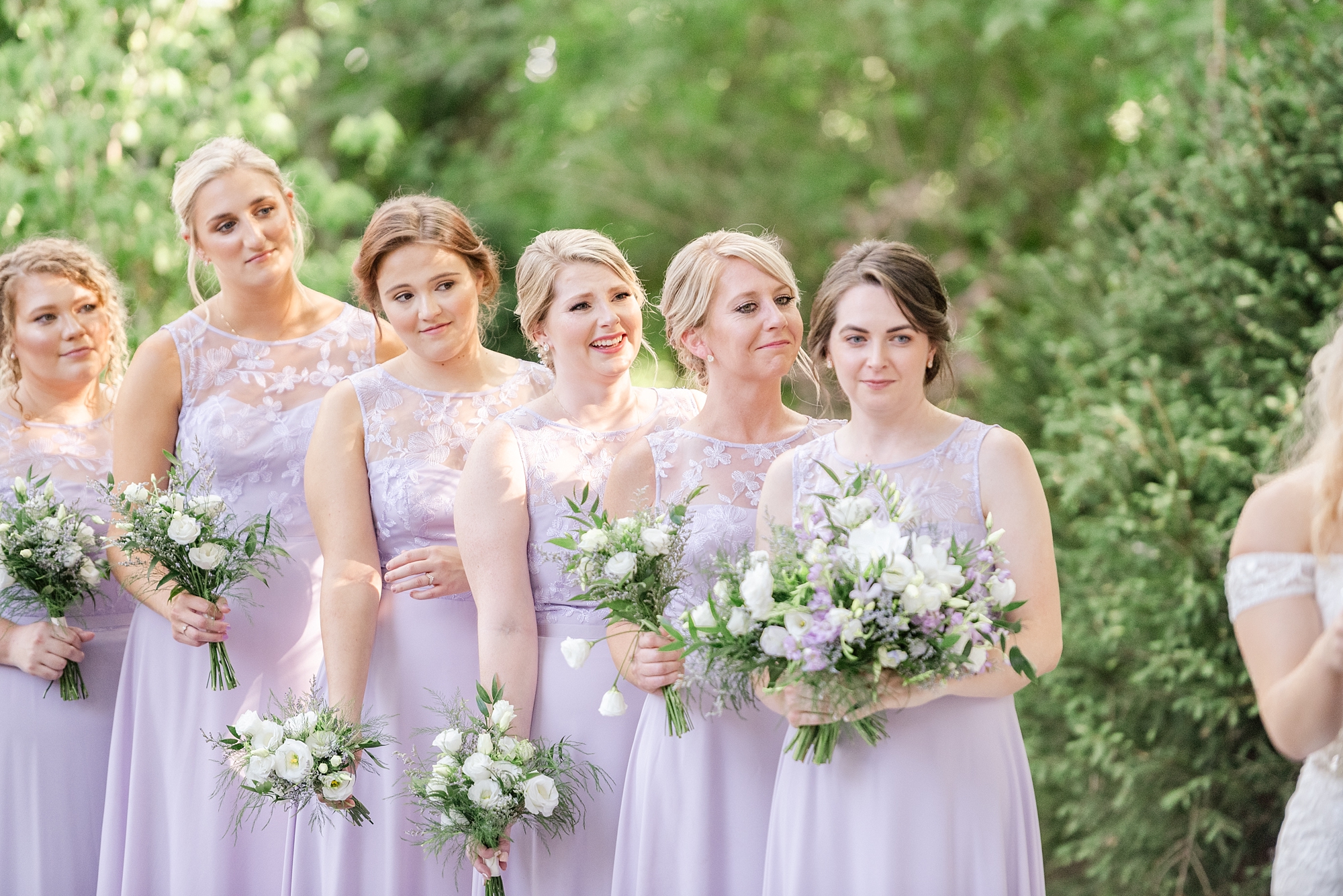 bridesmaids in purple gowns watch bride and groom exchange vows