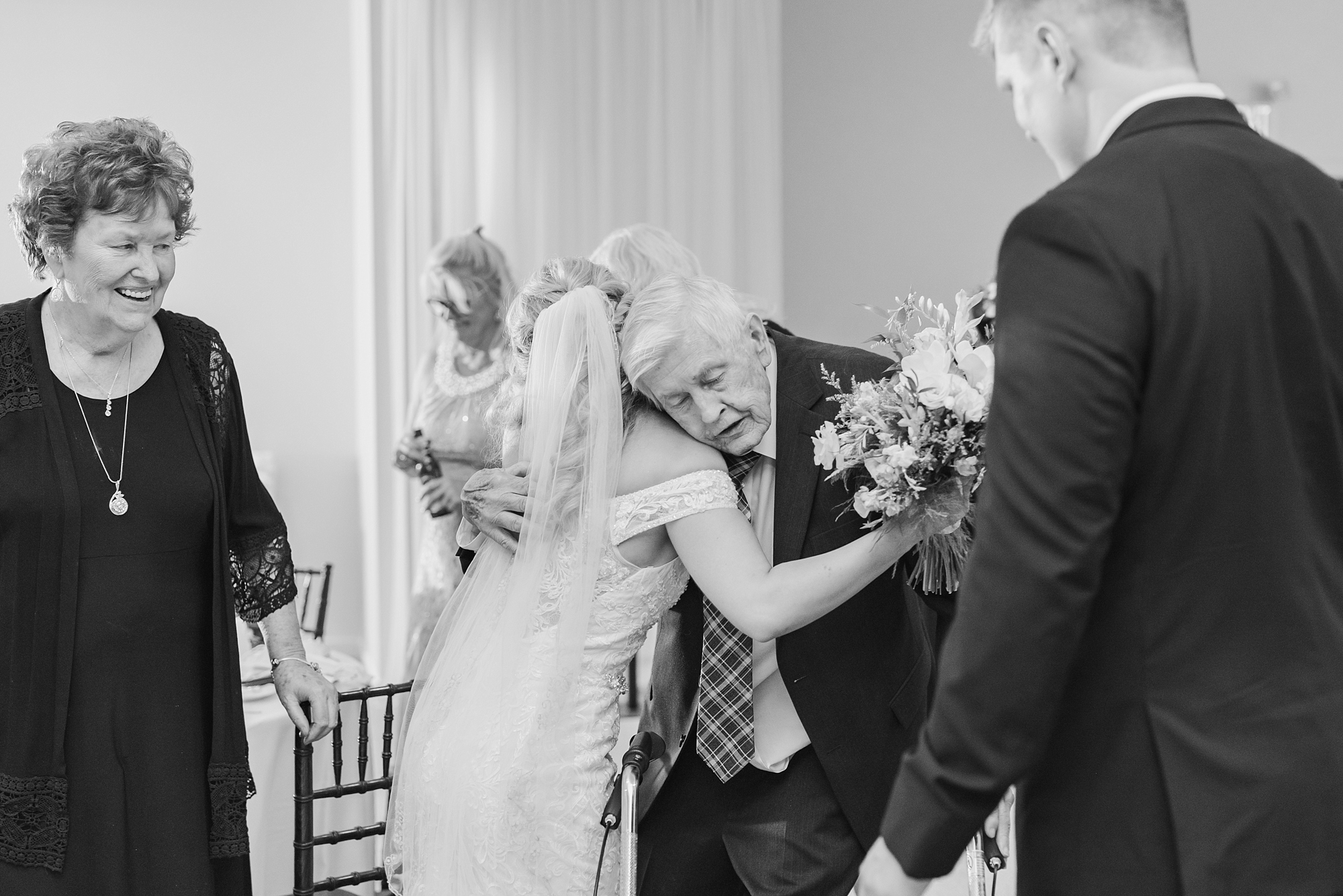 bride hugs grandfather at wedding reception