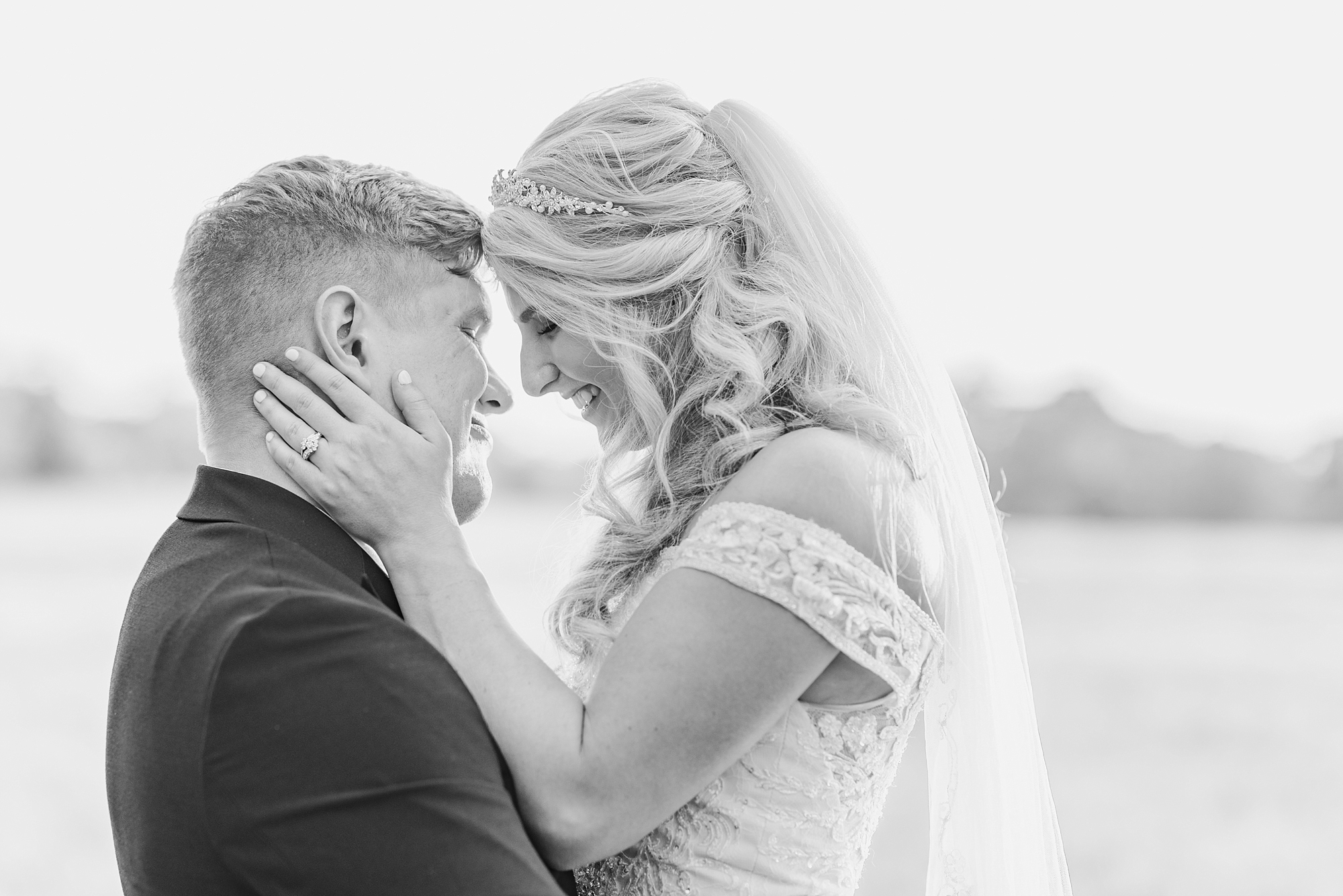 bride and groom touch noses during wedding portraits