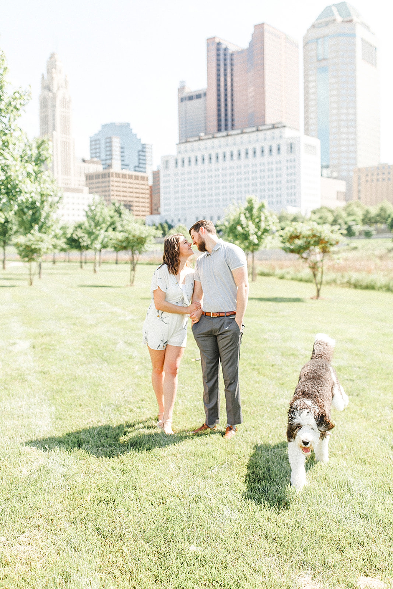 couple walks in park with dog in Downtown Columbus