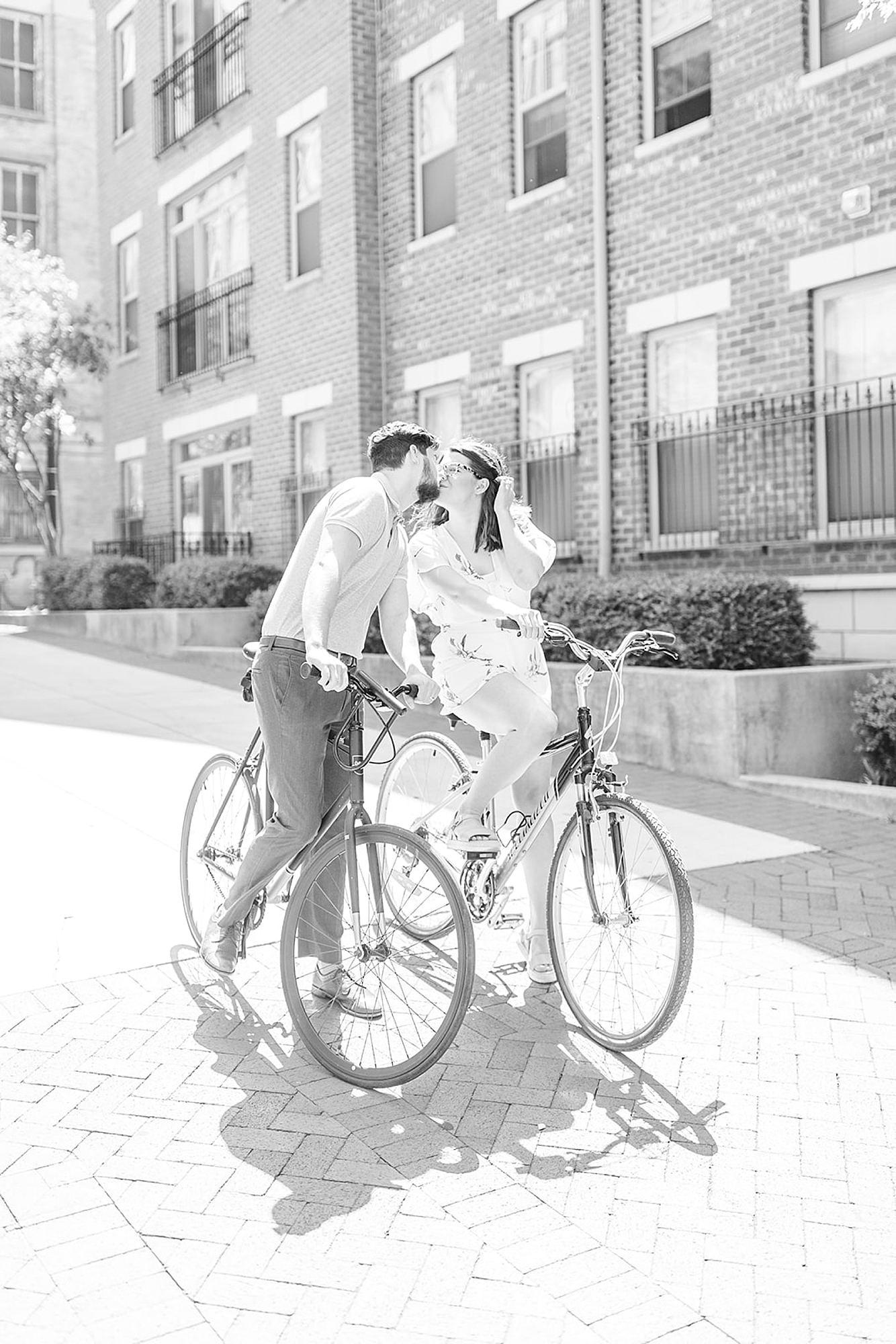 husband leans over bike to kiss wife