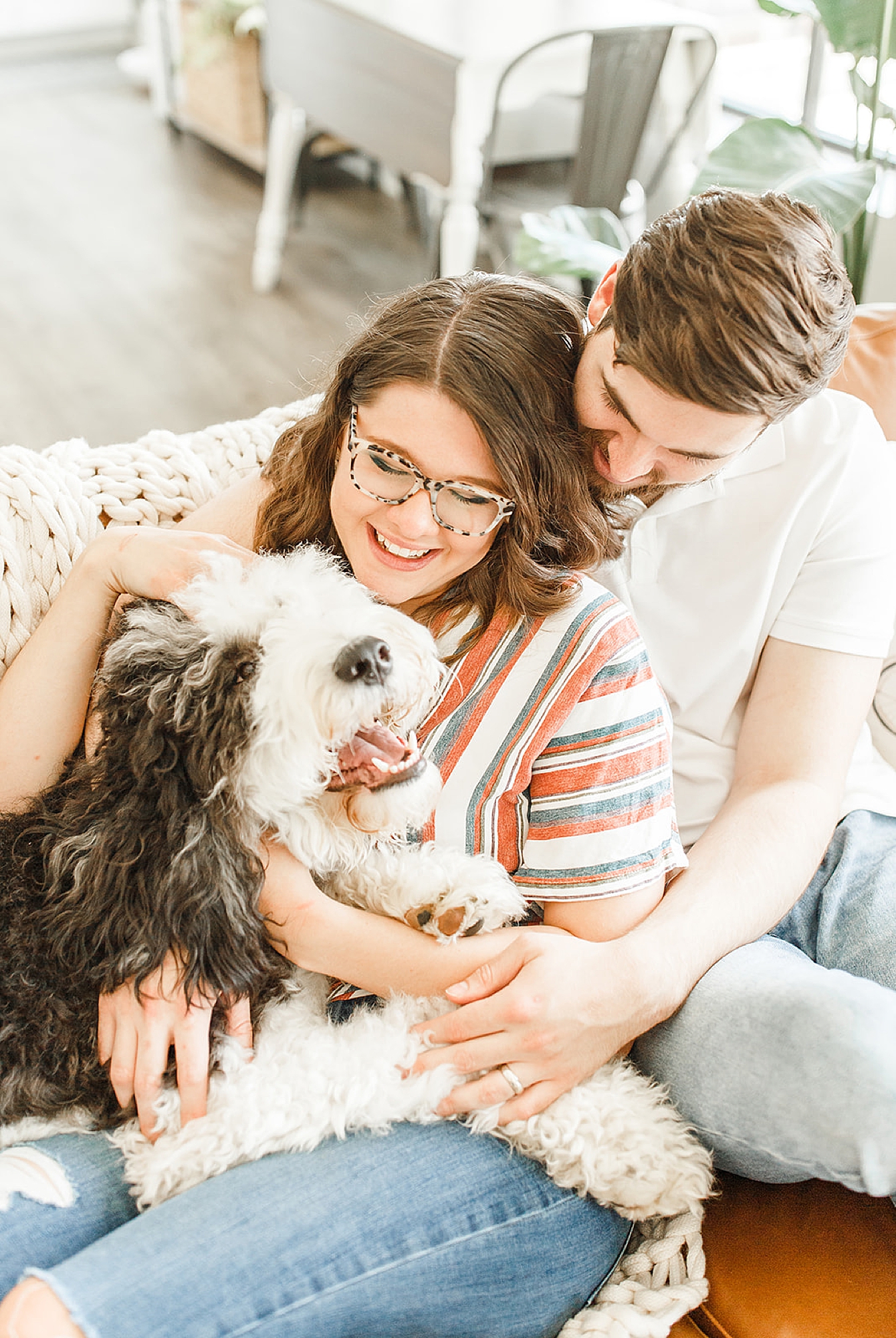 couple snuggles with dog during at home lifestyle portraits at home