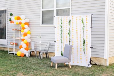 Ohio backyard baby shower with photo backdrop covered in orange peels