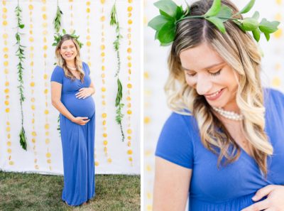 pregnant mom in blue dress holds baby belly during maternity portraits by citrus backdrop
