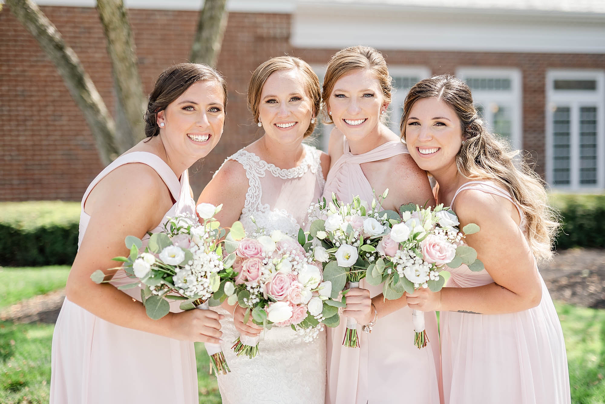 bride smiles with bridesmaids in pale pink gowns at Wedgewood Golf & Country Club