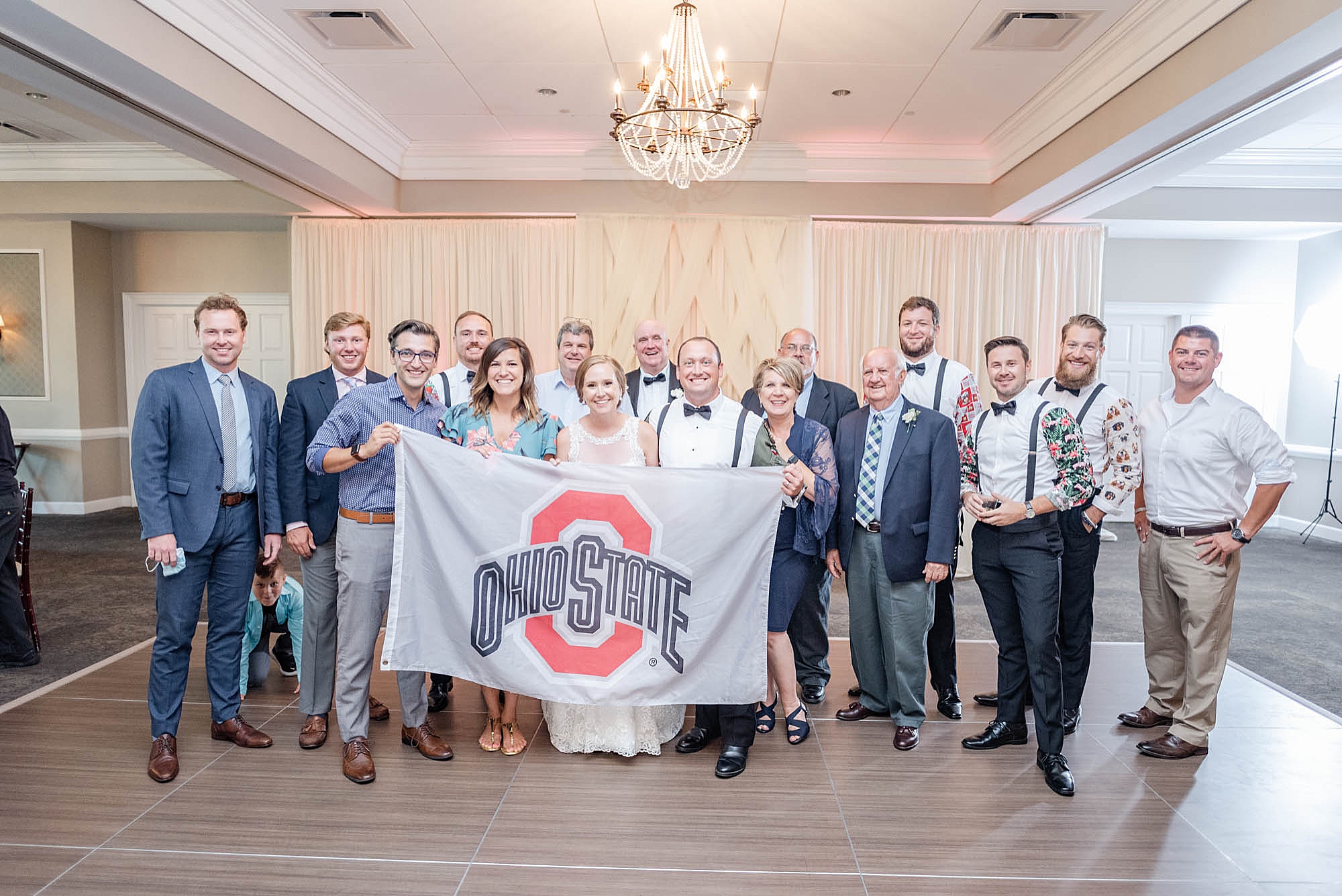 bride and groom pose with Ohio State University alumni