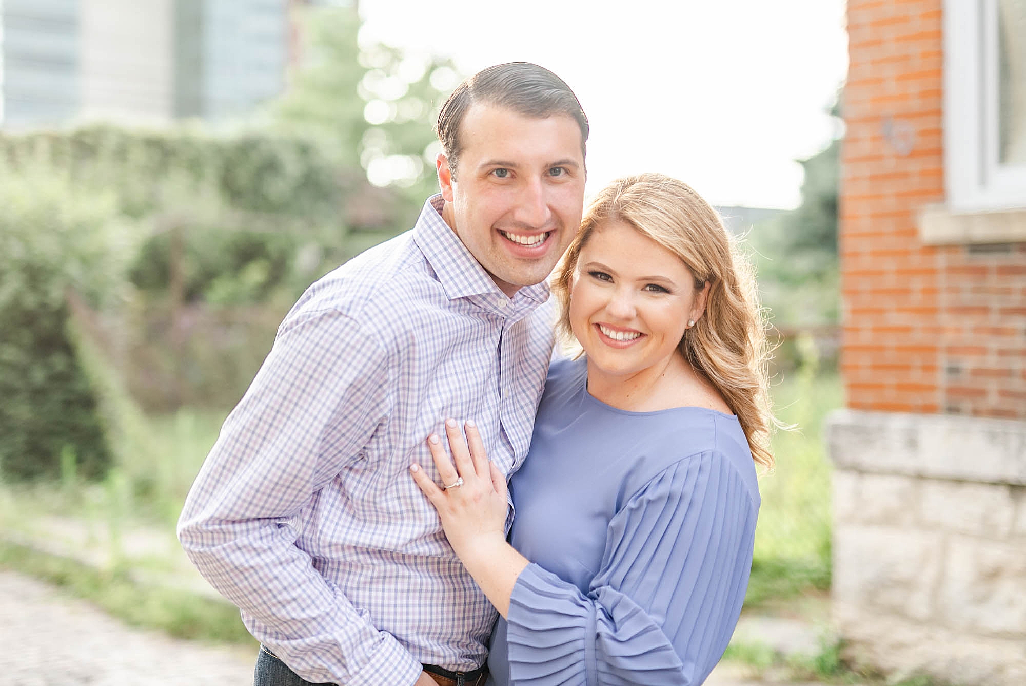 engaged couple in blue shirts smiles at camera during Schiller Park engagement session