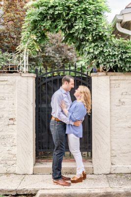bride and groom pose by wrought iron gate in Ohio