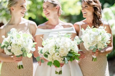 bride and bridesmaids with all white bouquets pose at Gervasi Vineyard