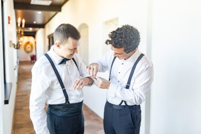 groomsman adjusts cufflinks for groom