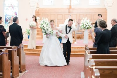 bride and groom walk up aisle after church wedding