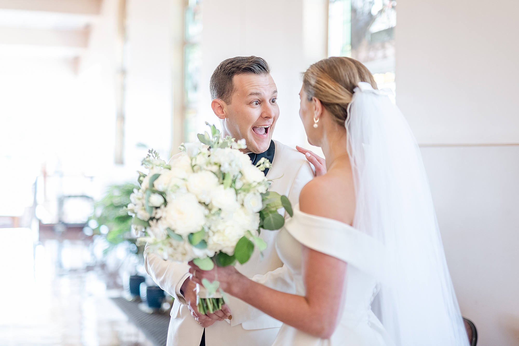groom laughs with bride outside church wedding ceremony