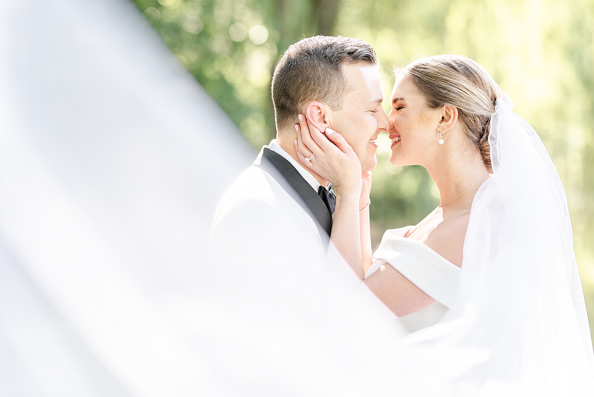 newlyweds kiss while veil twirls around them