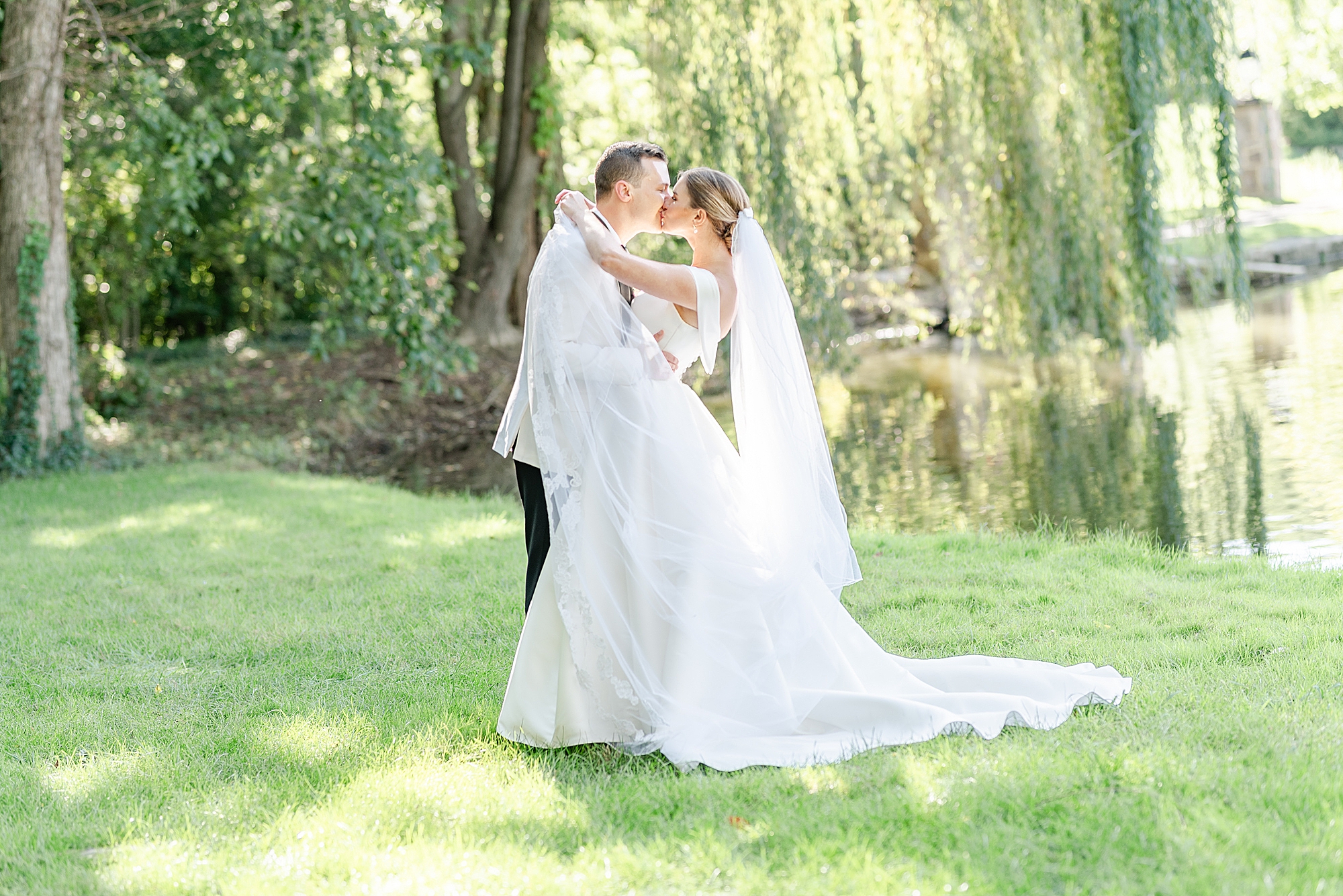 newlyweds kiss under willow tree