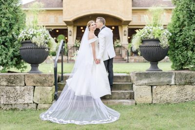 bride and groom stand on staircase at Gervasi Vineyard