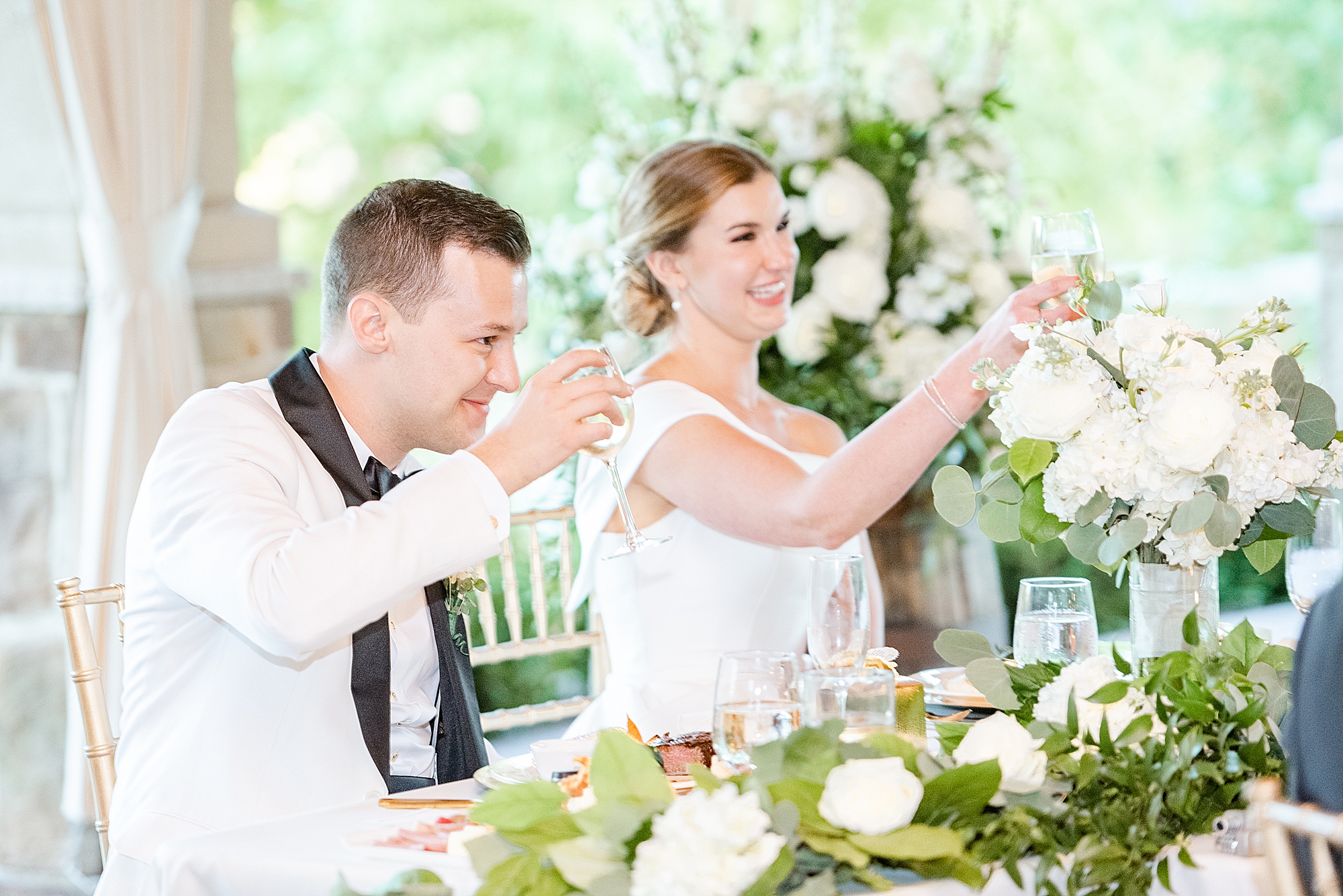 bride lifts wine glass during toast at Ohio wedding reception