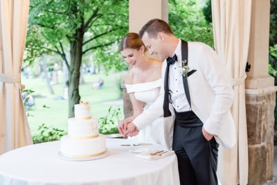 newlyweds cut wedding cake at Gervasi Vineyard