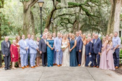 family poses with bride and groom after Forsyth Park wedding ceremony