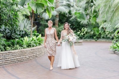 bride walks down aisle at Franklin Park Conservatory with mother