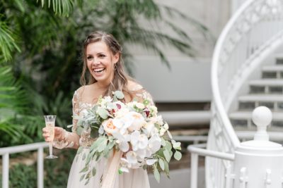 bride laughs with glass of champagne