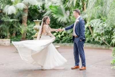 groom twirls bride during Palm house wedding portraits