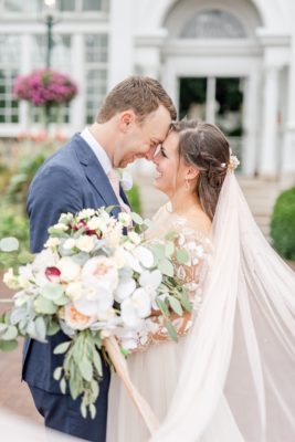 bride and groom stand nose to nose outside Franklin Park Conservatory