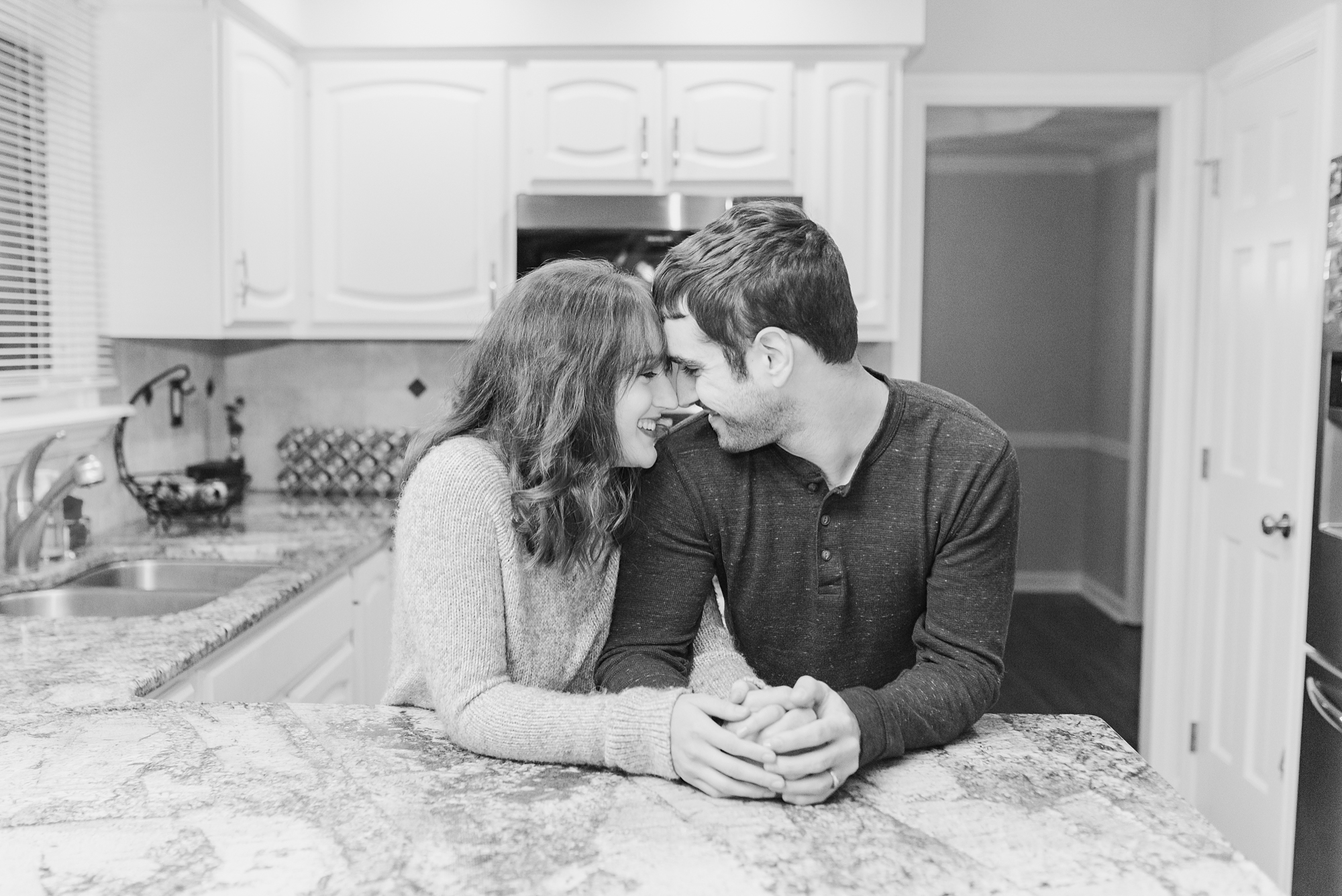 bride and groom stand nose to nose in kitchen for first anniversary portraits