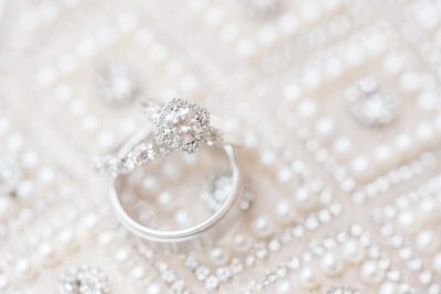 bride's ring sits on wedding dress