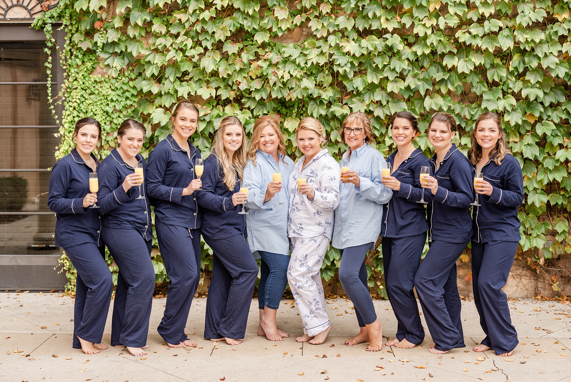 bride poses with bridesmaids and moms