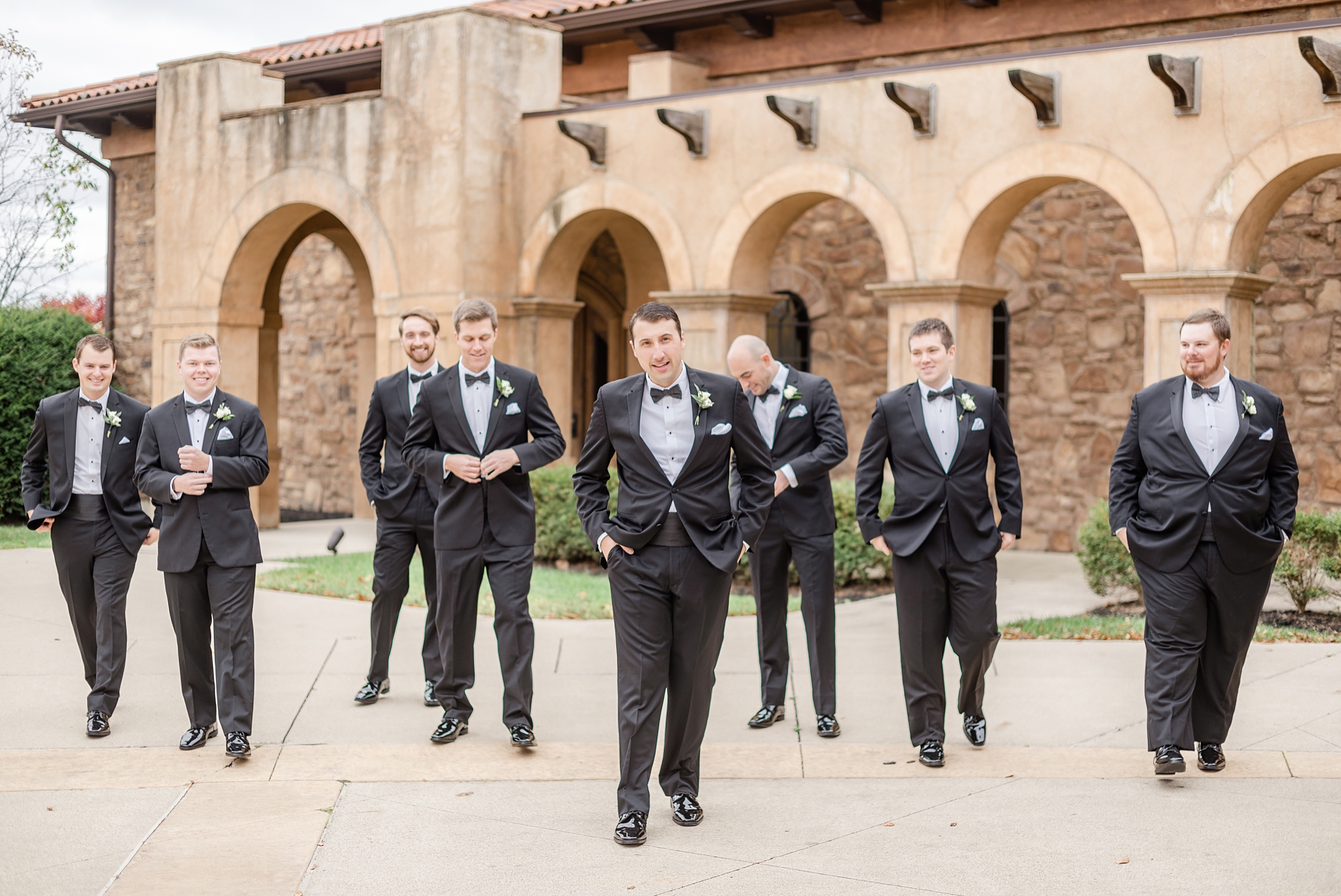 groom walks outside The Club at Corazon with groomsmen