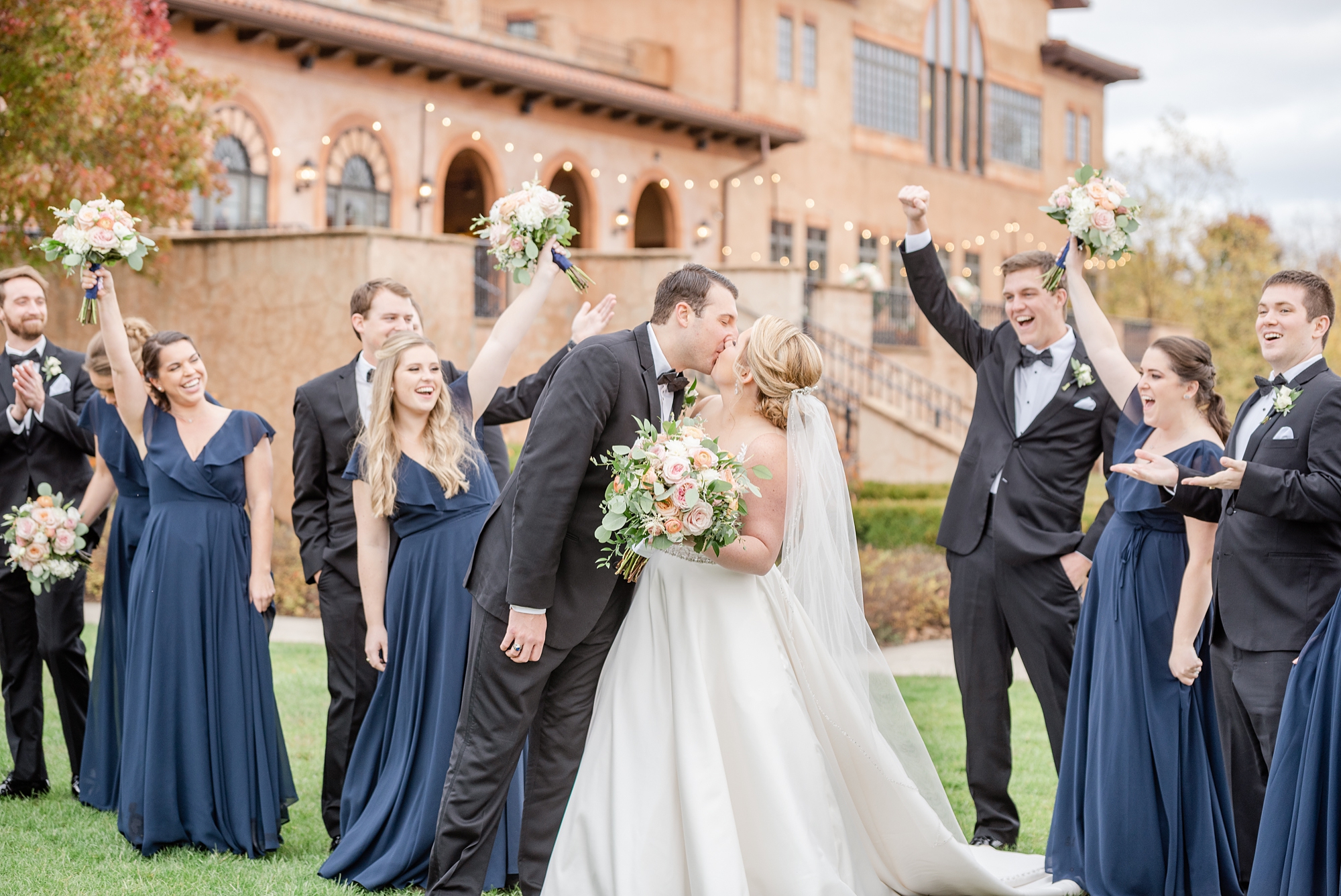 newlyweds kiss while bridal party cheers