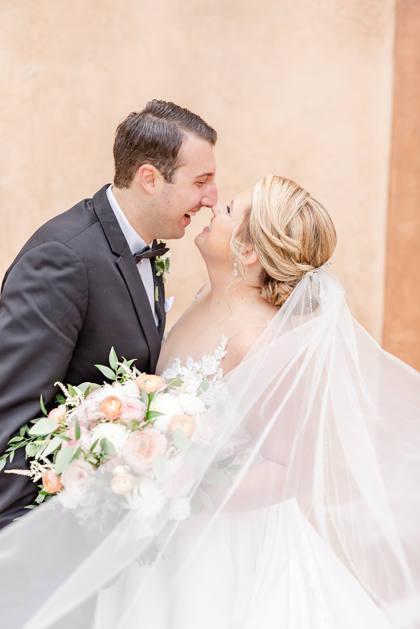 newlyweds touch noses during wedding photos