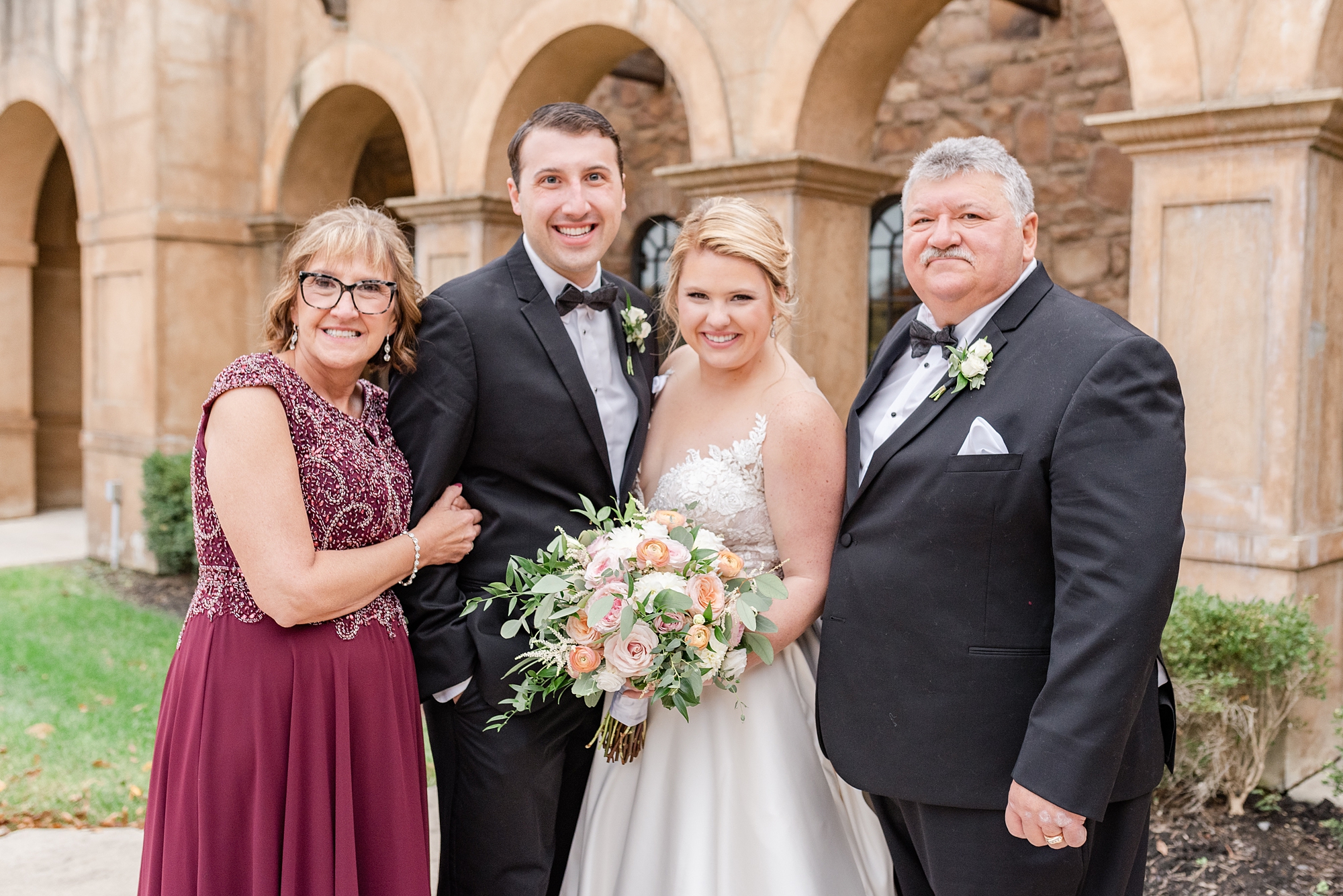 parents of groom pose with newlyweds