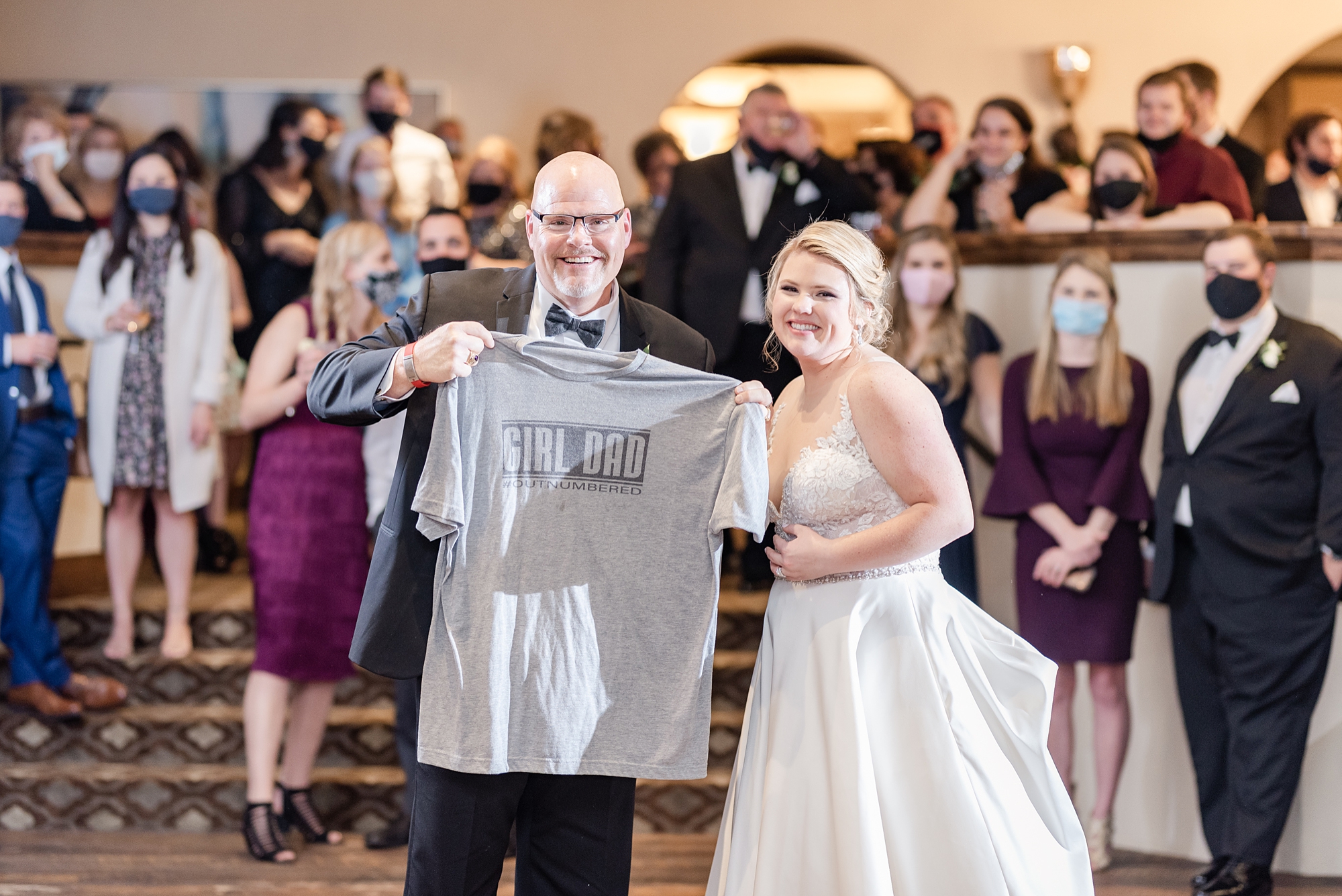 bride gifts dad a t-shirt during wedding reception
